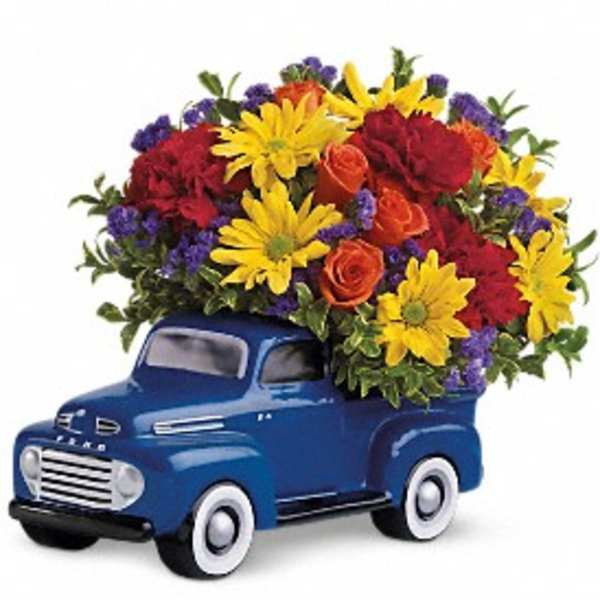 Blue truck figurine topped with a colorful flower arrangement