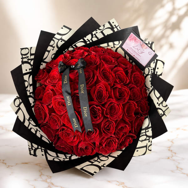 Large bouquet of red roses wrapped in black and white paper with a ribbon
