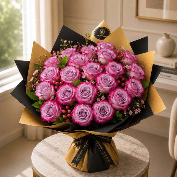 Bouquet of pink roses wrapped in black and gold paper