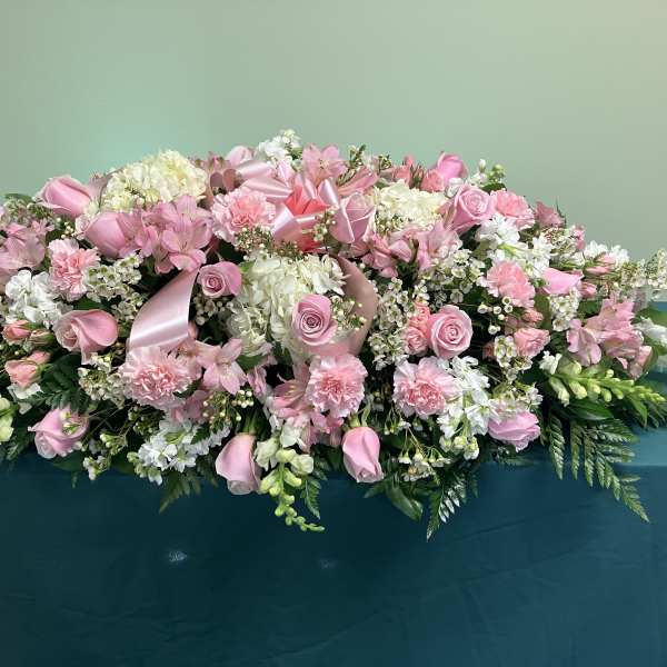 Large pink and white floral arrangement with ribbon accents