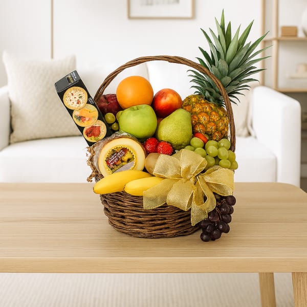 Fruit basket with pineapple, grapes, bananas, and packaged snacks