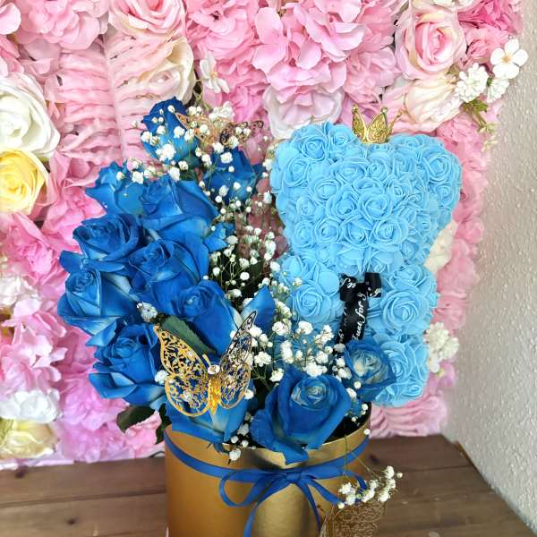 Blue rose arrangement in a gold hatbox with butterfly accents