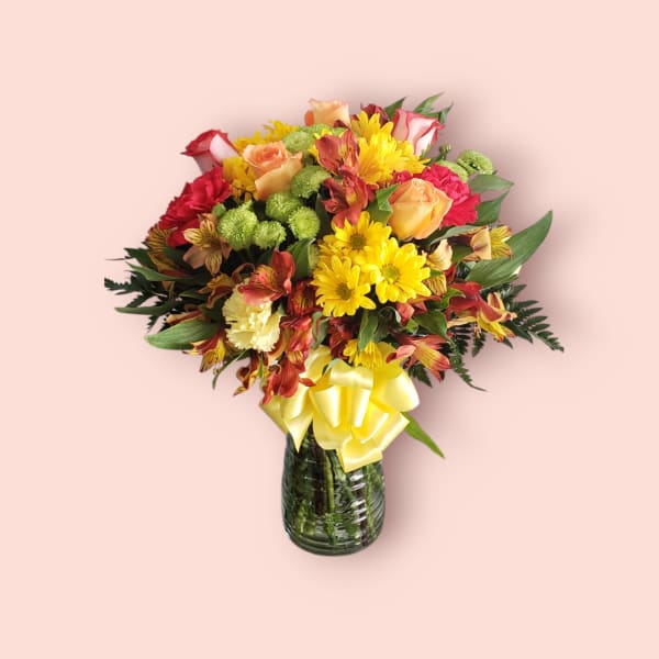 Mixed bouquet of roses, chrysanthemums, and alstroemeria in a glass vase