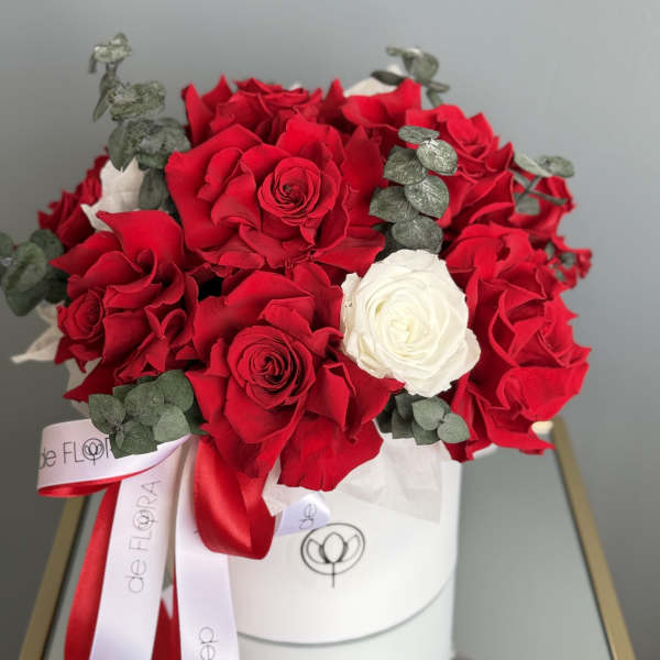 Bouquet of red and white roses with eucalyptus in a white hat box