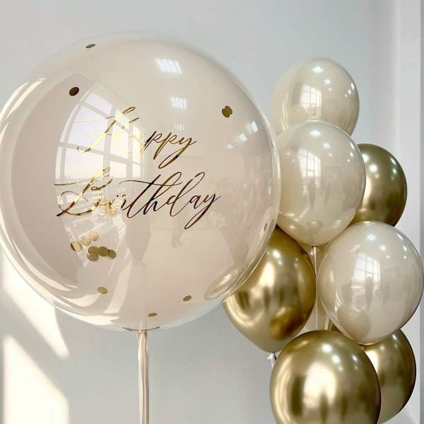 Birthday balloons in cream and gold with a large clear balloon