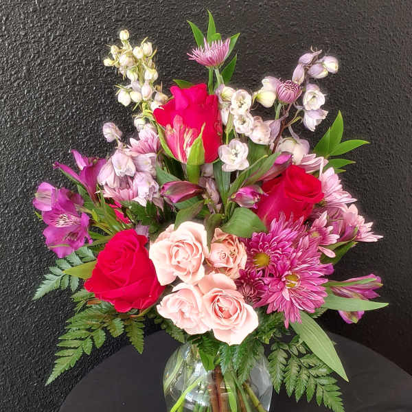 Mixed pink and red bouquet in a clear glass vase