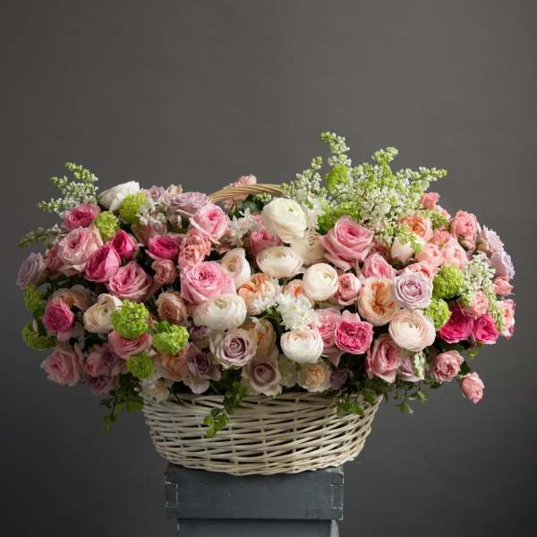Basket of pink and white roses with green accents