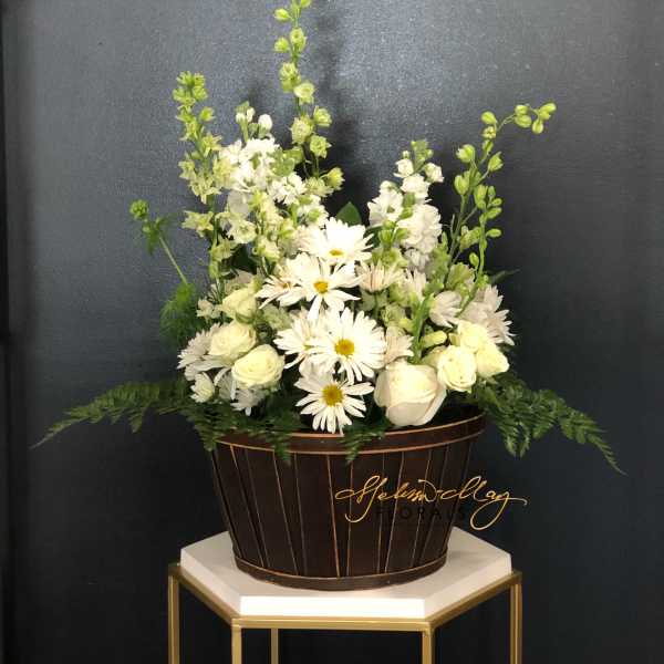 White flowers arranged in a brown basket with tall green stems