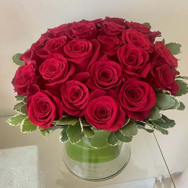 Compact dome of red roses in a clear glass vase