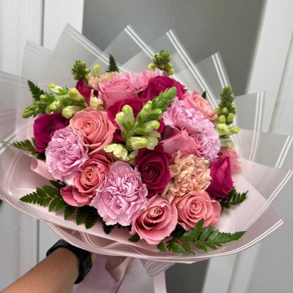 Pink rose and carnation bouquet wrapped in pale pink paper