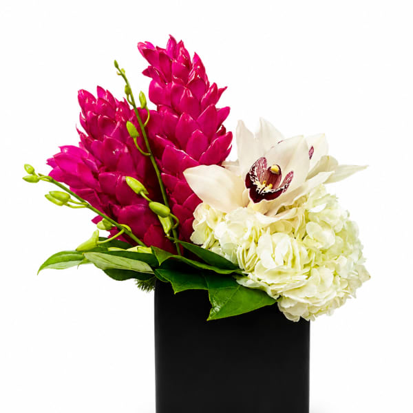 Pink and white flowers arranged in a black square vase