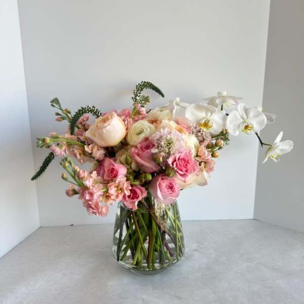 Pink and white flower arrangement in a clear glass vase