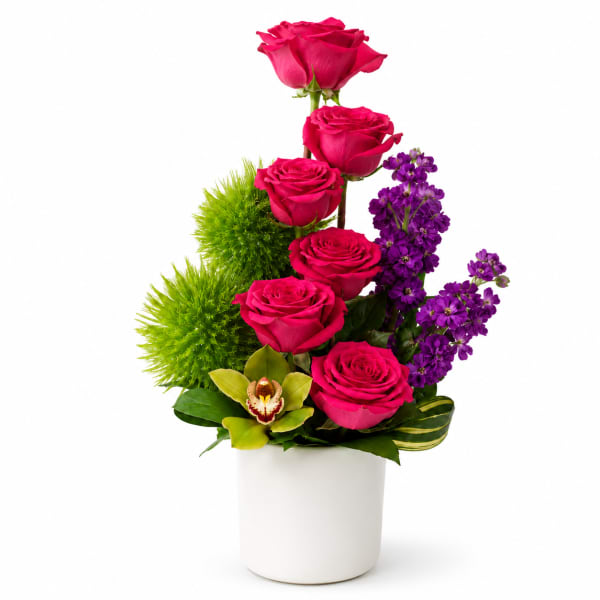 Pink roses and purple flowers arranged in a white vase