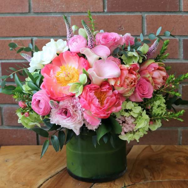 Pink and white mixed bouquet in a green glass vase