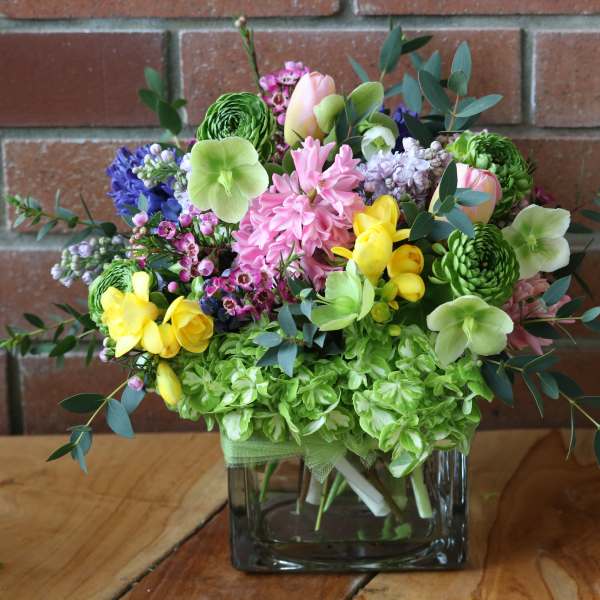Colorful mixed bouquet in a square glass vase