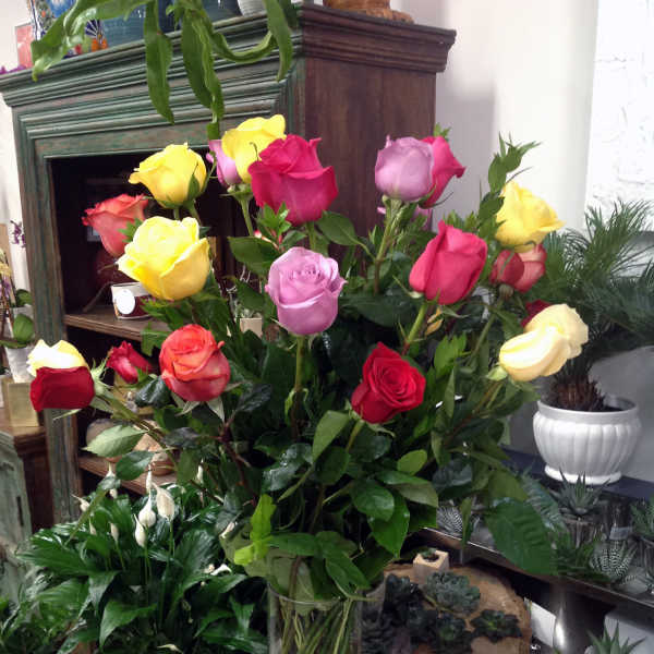 Mixed roses in a clear glass vase with white blooms at the base