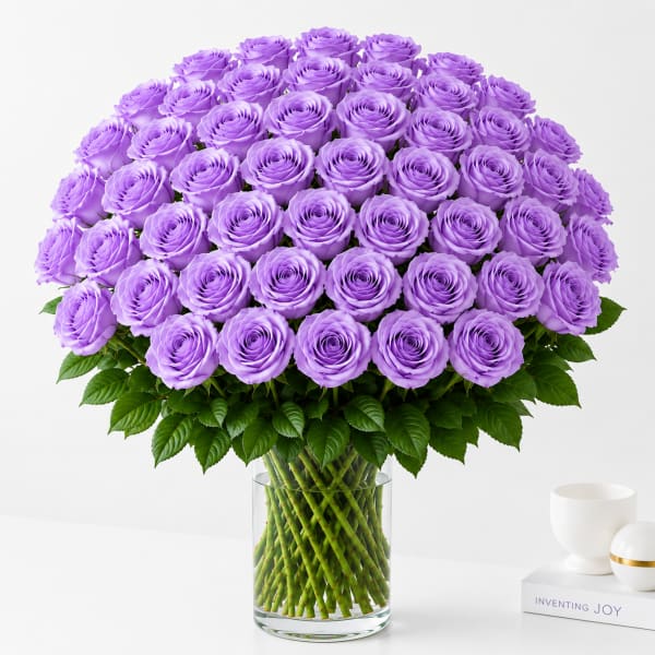 Large bouquet of lavender roses in a clear glass vase