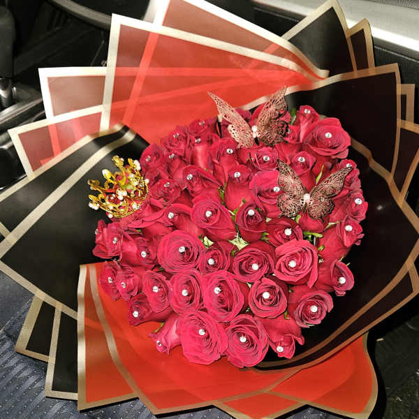 Bouquet of red roses with decorative butterflies and a crown wrap