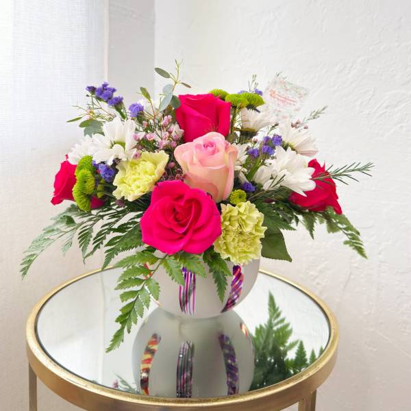 Mixed bouquet of pink and white roses with daisies in a white vase