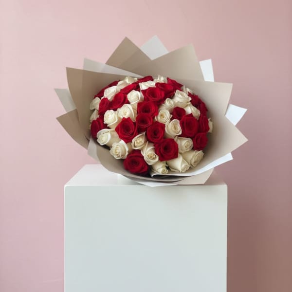 Bouquet of red and white roses wrapped in beige paper