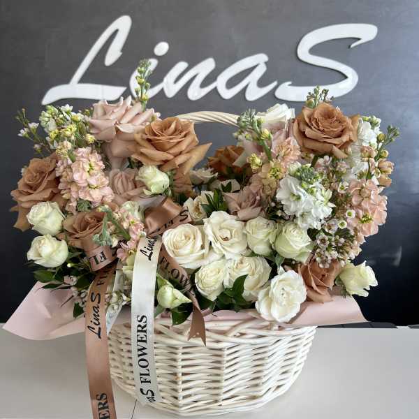 Basket arrangement of cream, blush, and tan roses with ribbons