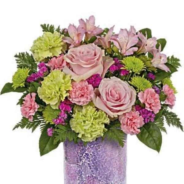Pink roses and mixed flowers arranged in a purple vase