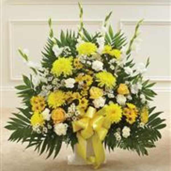 Yellow and white floral standing spray with a ribbon on a white easel