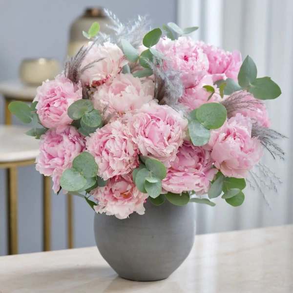 Pink peony bouquet in a gray vase with eucalyptus