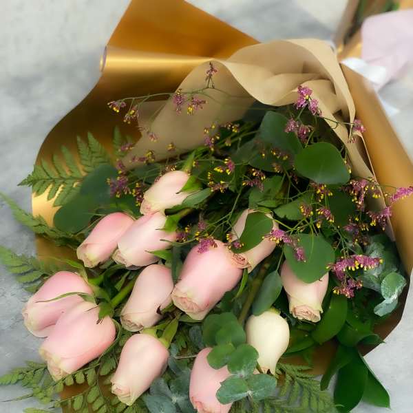 Bouquet of pale pink roses with greenery and gold wrapping