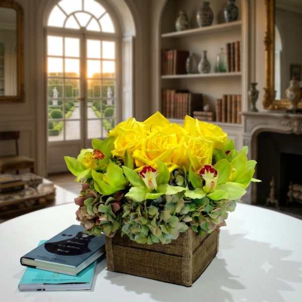 Yellow roses and green orchids in a square burlap-covered box