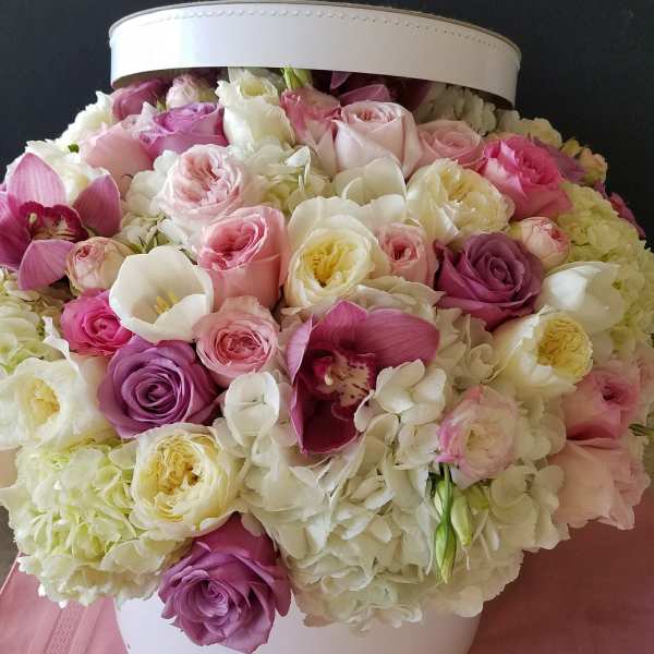 Pink and white roses with hydrangeas in a white hatbox