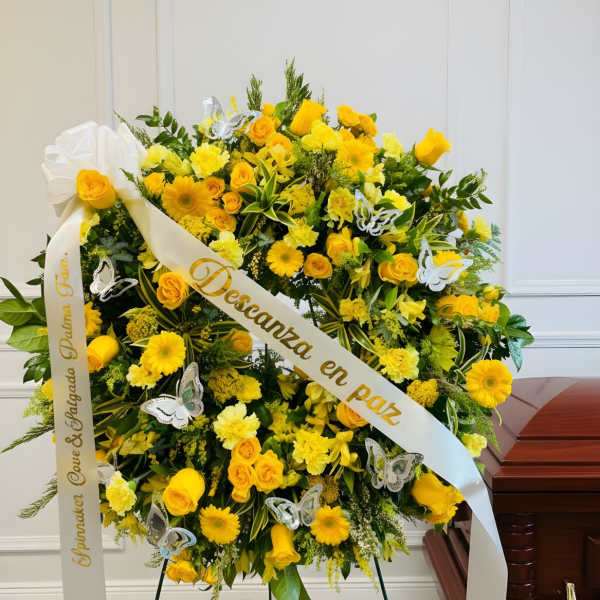 Yellow floral funeral wreath with white ribbon and butterfly accents