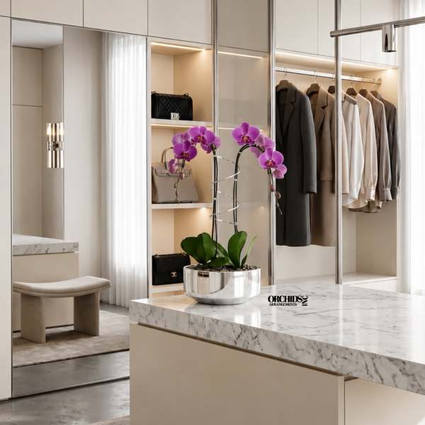 Purple orchids in a silver pot on a marble island in a modern closet