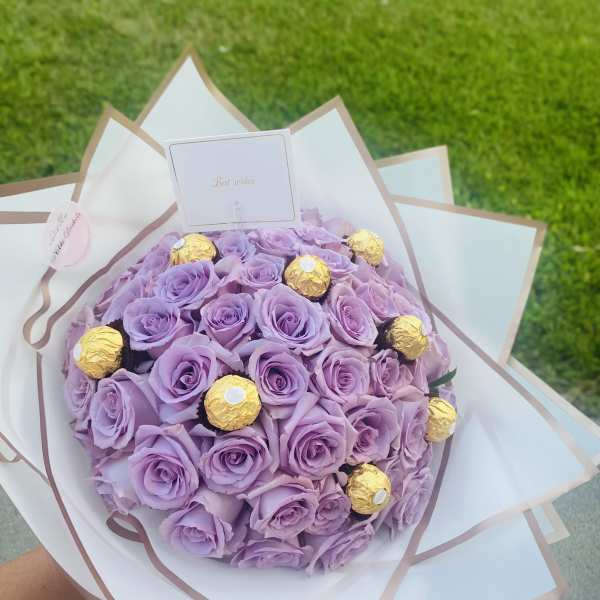 Lavender rose bouquet with gold-wrapped chocolates and a small card