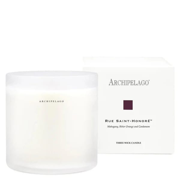 White three-wick candle in a frosted glass jar with a box behind it