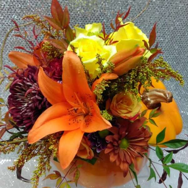 Bouquet of orange lilies, yellow roses, and dark mums