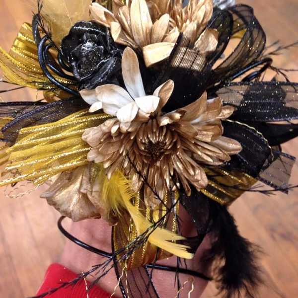 Black, gold, and white floral hair accessory with feathers