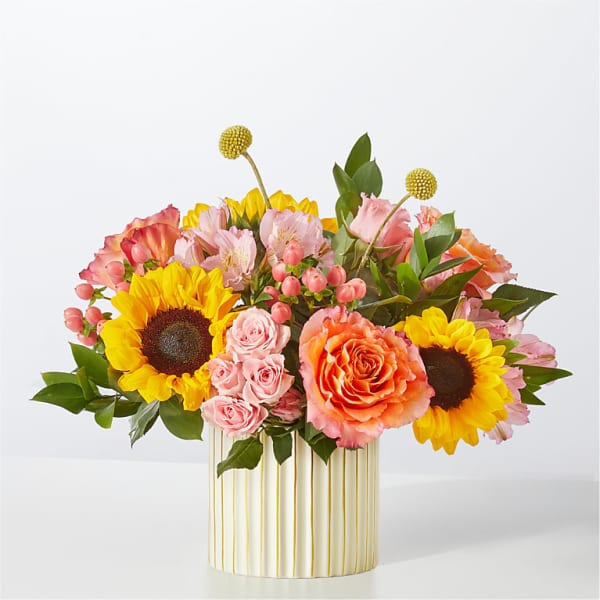 Mixed bouquet with sunflowers, pink roses, and orange blooms in a striped vase