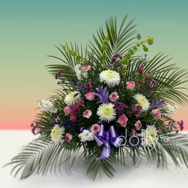 Large floral arrangement with pink, white, and purple flowers and palm fronds
