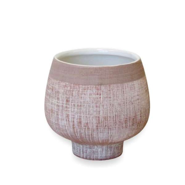 Textured pink ceramic vase on a white background