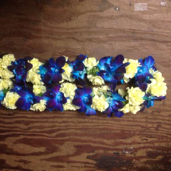 Blue orchids and pale yellow carnations arranged in a long garland