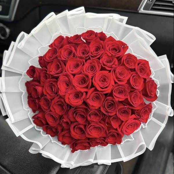 Bouquet of red roses wrapped in white paper