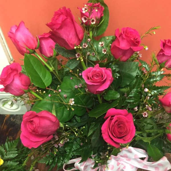 Bouquet of hot pink roses with greenery and a pink polka-dot ribbon