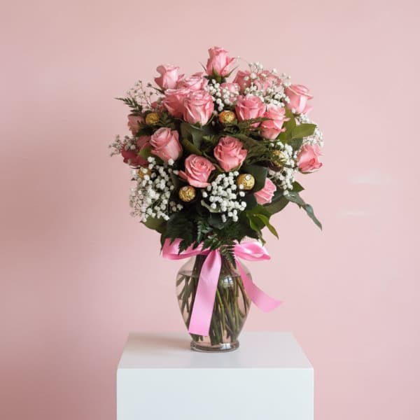 Pink rose bouquet in a glass vase with a pink ribbon