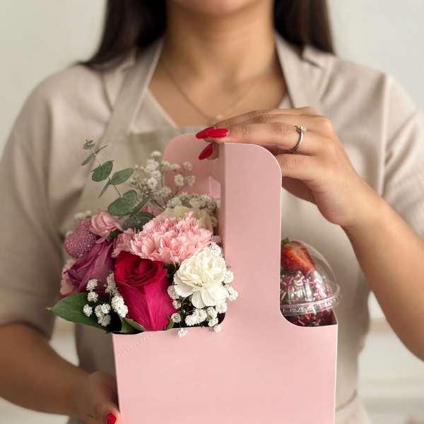 Pink gift box with mixed flowers and a dessert cup