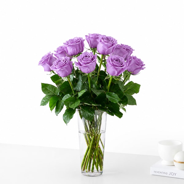 Lavender roses arranged in a clear glass vase