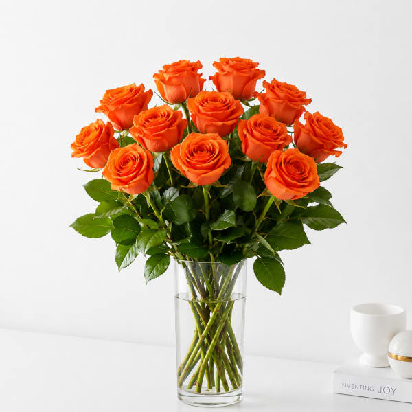 Orange roses arranged in a clear glass vase