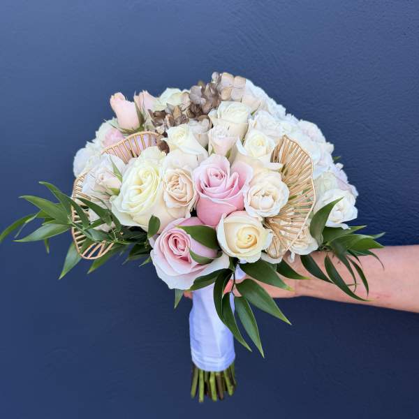 Wedding bouquet of pink and white roses with gold fan accents