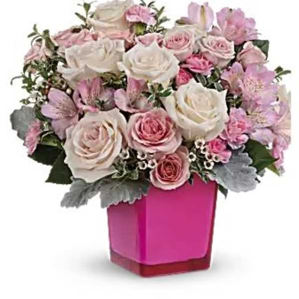 Pink and white roses arranged in a bright pink vase