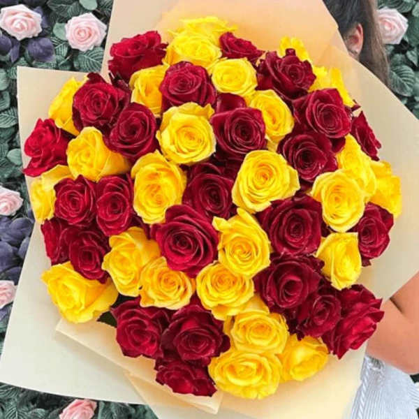 Bouquet of red and yellow roses wrapped in beige paper